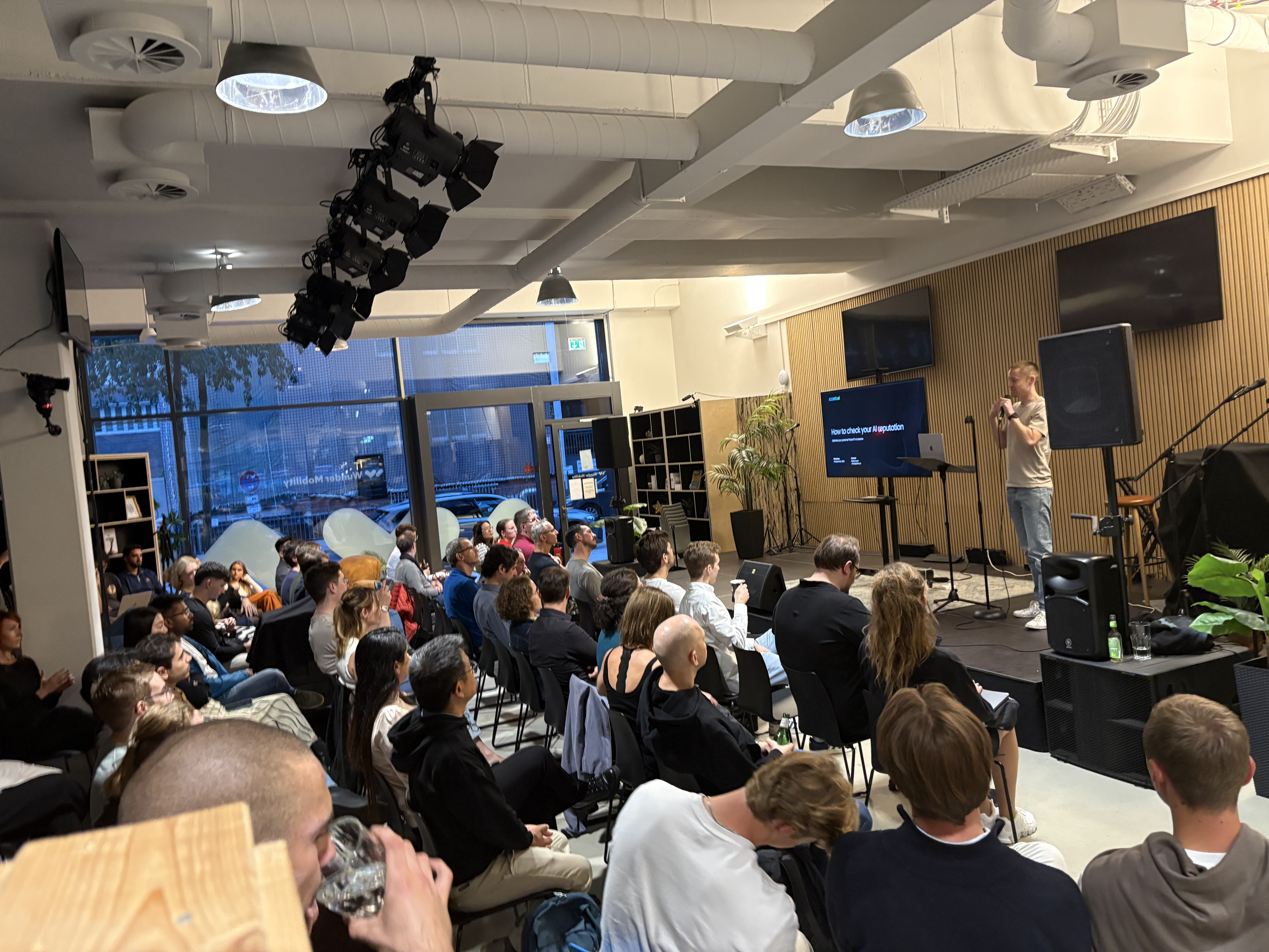 Niclas Aunin presenting on AI reputation and visibility to a seated audience at a technology event at the House of AI in Hamburg.
